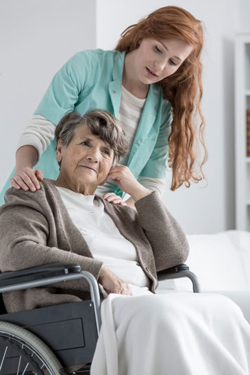 Nurse caring for elderly woman in wheelchair