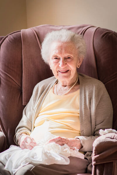 Elderly woman setting in chair with a smile